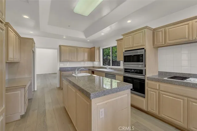 a kitchen with granite countertop a sink stove and refrigerator