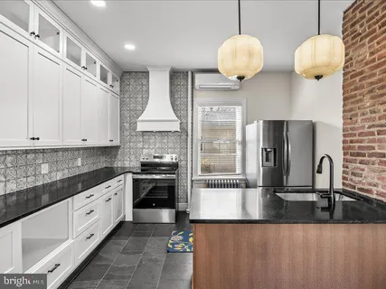 a kitchen with stainless steel appliances granite countertop a sink a stove and a refrigerator