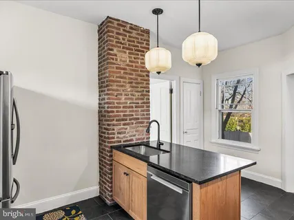 a kitchen with stainless steel appliances granite countertop a sink a oven a stove and a wooden floors