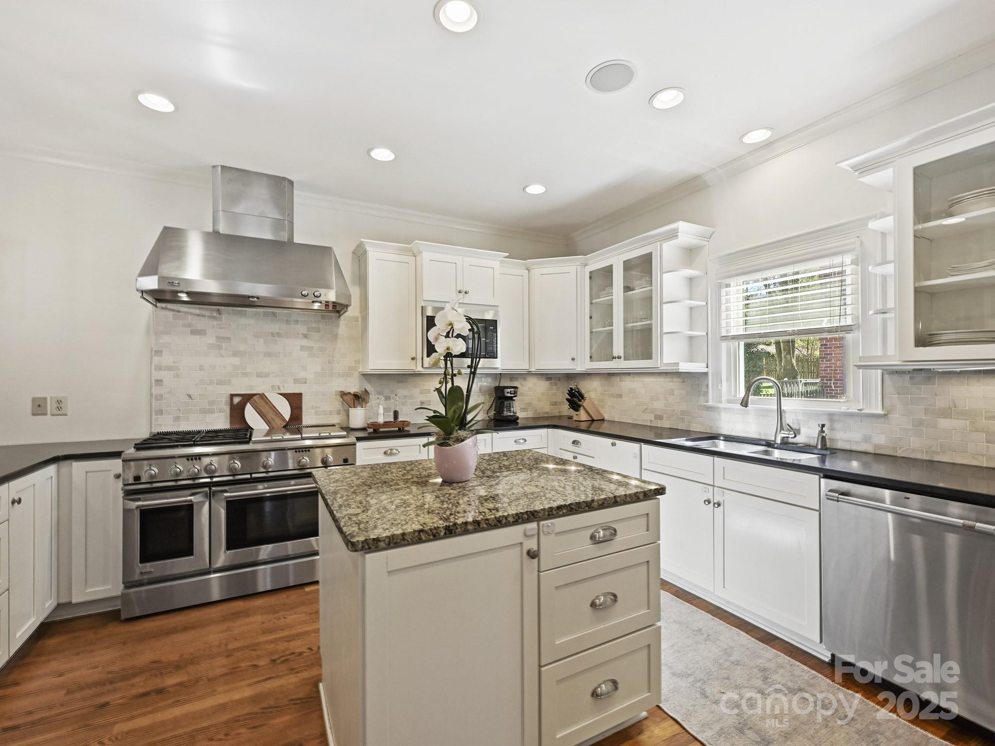 3915 Ayscough Road Charlotte, NC 28211 - Photo 13 of 45 a kitchen with stainless steel appliances granite countertop a sink stove cabinets and wooden floor