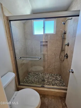 a bathroom with a toilet and a shower
