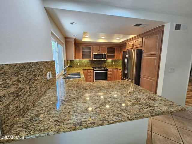 a view of kitchen with refrigerator stove microwave and cabinets
