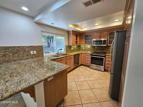 a kitchen with stainless steel appliances granite countertop a sink stove and cabinets