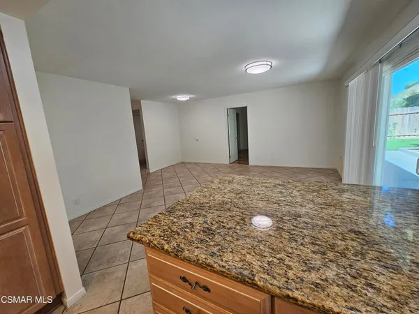 a view of a kitchen with granite countertop a sink and a stove