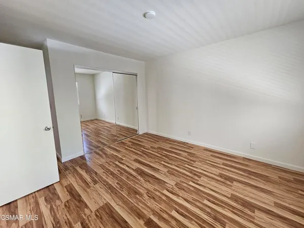 a view of a room with wooden floor and bench