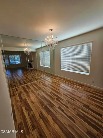 a view of a room with wooden floor and chandelier