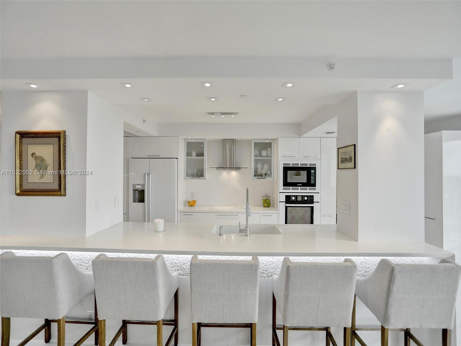a kitchen with stainless steel appliances granite countertop a table and chairs