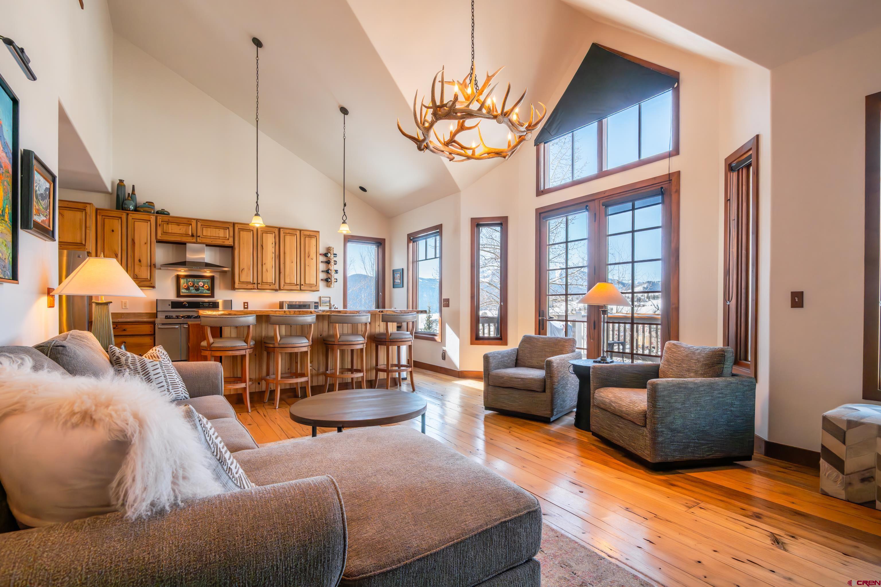 11 Castle Road Crested Butte, CO 81225 - Photo 11 of 45 a living room with furniture a chandelier and a flat screen tv