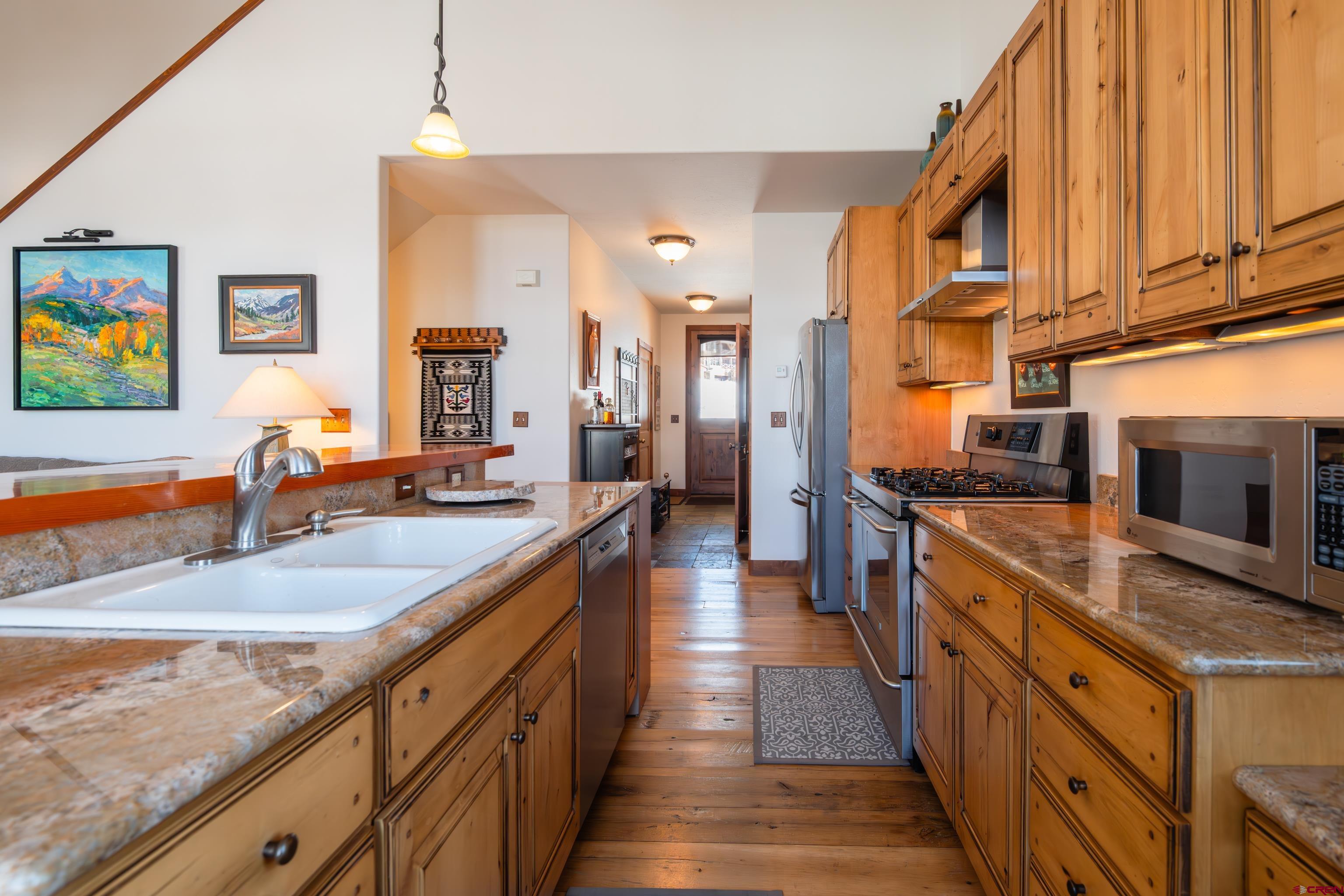 11 Castle Road Crested Butte, CO 81225 - Photo 4 of 45 a large kitchen with stainless steel appliances granite countertop a lot of counter space and wooden floors