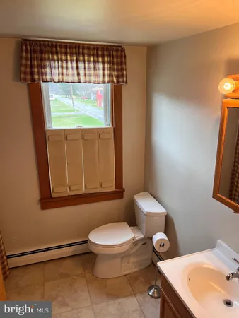 a bathroom with a toilet a sink and a window