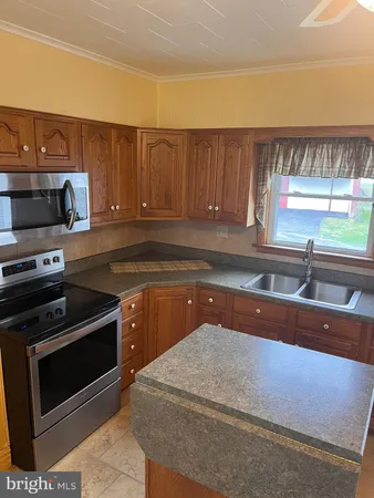 a kitchen with a sink and a stove with wooden floor