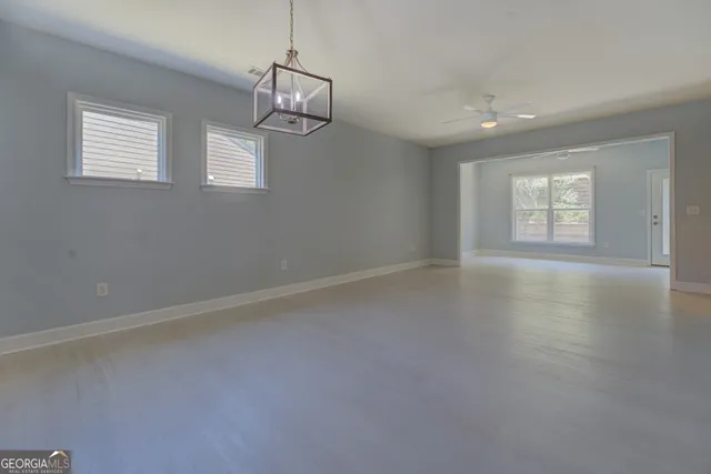 an empty room with windows and chandelier