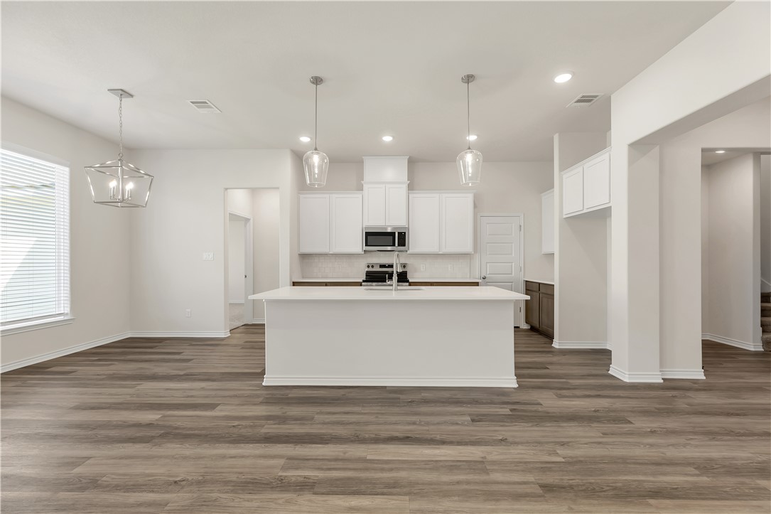 1931 Pinemont View Drive Bryan, TX 77807 - Photo 13 of 43 a view of kitchen with stainless steel appliances granite countertop wooden floor sink and a granite counter top