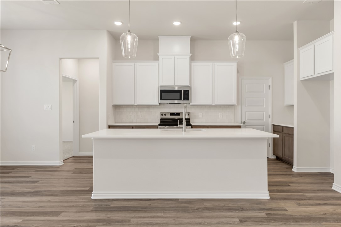 1931 Pinemont View Drive Bryan, TX 77807 - Photo 14 of 43 a kitchen with kitchen island white cabinets and refrigerator