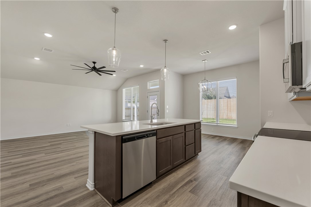 1931 Pinemont View Drive Bryan, TX 77807 - Photo 22 of 43 a kitchen with stainless steel appliances granite countertop a sink a stove and a wooden floors