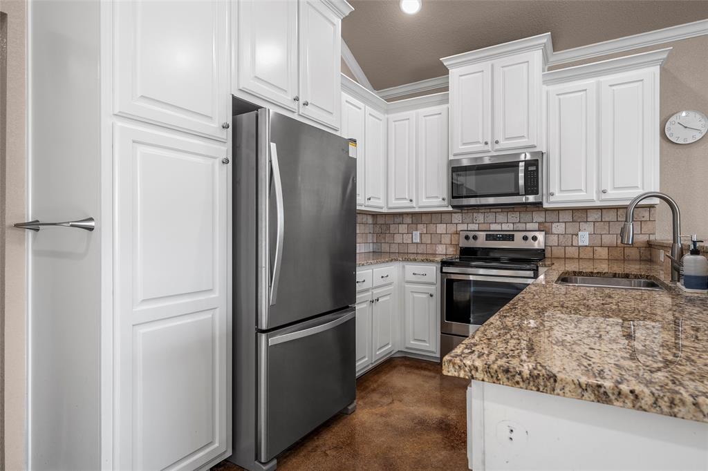 402 Spring Street McGregor, TX 76657 - Photo 7 of 16 a kitchen with a refrigerator stove and microwave