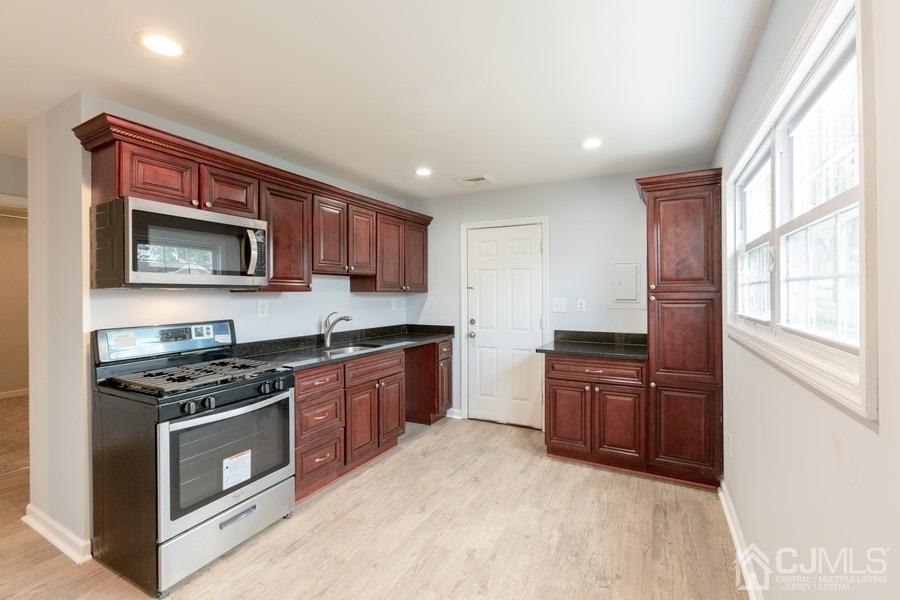 32 Winthrop Road Edison, NJ 08817 - Photo 3 of 15 a kitchen with stainless steel appliances granite countertop a stove top oven a sink dishwasher a microwave oven and a refrigerator with wooden cabinets