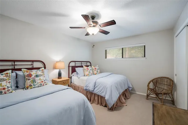 a bedroom with two beds and ceiling fan