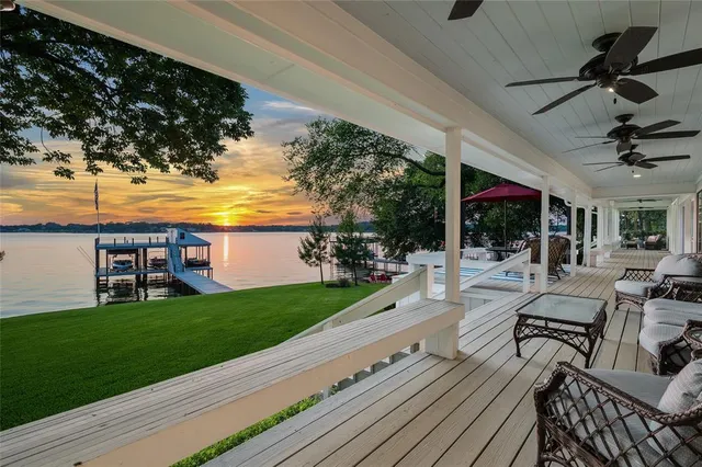 a view of a patio with dining table and chairs with wooden floor and fence