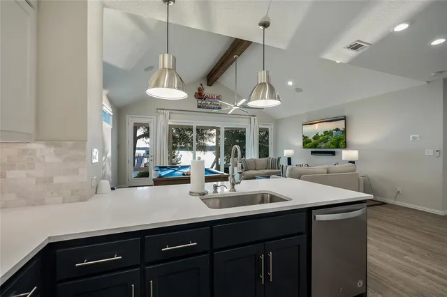 a kitchen with a sink a counter space and wooden floor
