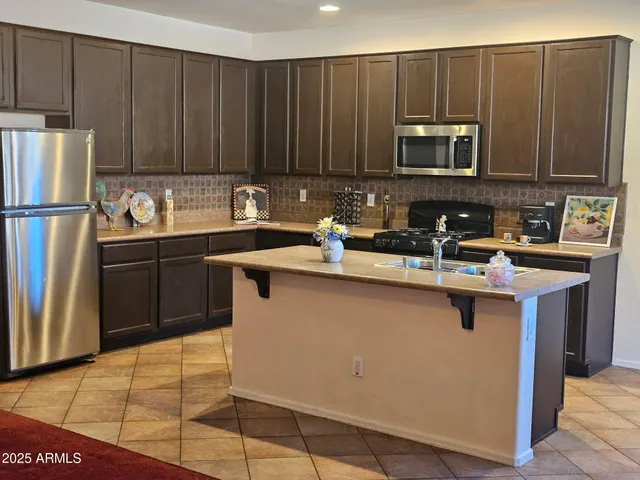 a kitchen with kitchen island a sink appliances and cabinets