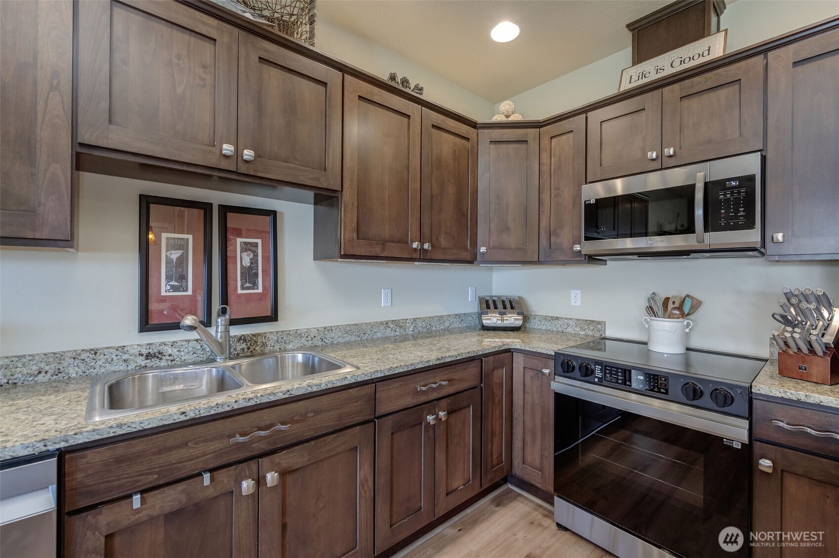 23318 Sunserra Loop, Unit B00 Quincy, WA 98848 - Photo 8 of 30 a kitchen with granite countertop a sink dishwasher stove and microwave with wooden cabinets
