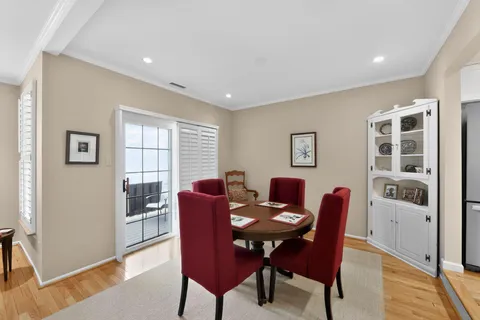 a balcony with wooden floor table and chairs