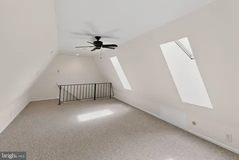 an empty room with a window and a ceiling fan