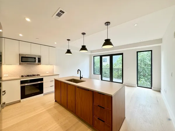 a kitchen with stainless steel appliances granite countertop a sink stove and refrigerator
