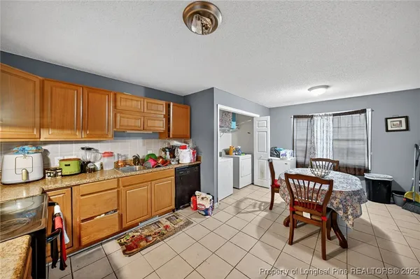 a kitchen with a table chairs and a refrigerator