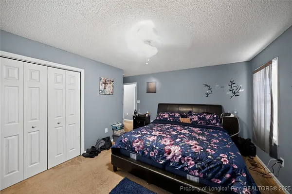 a bedroom with a large bed and a chandelier