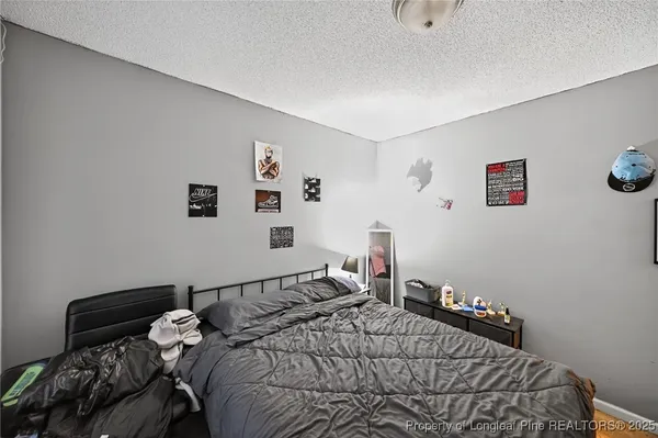 a bedroom with a bed and painting on the wall