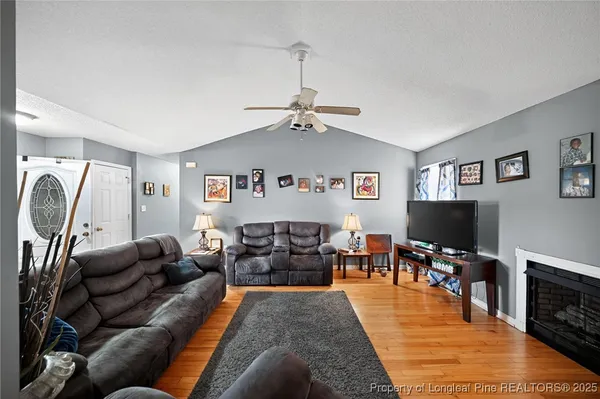a living room with furniture a flat screen tv and a fireplace