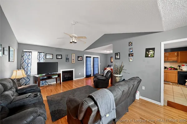 a living room with furniture a flat screen tv and fireplace