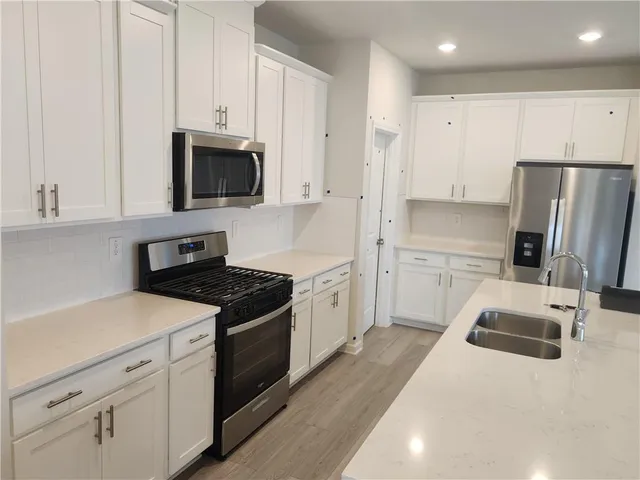 a kitchen with white cabinets and stainless steel appliances