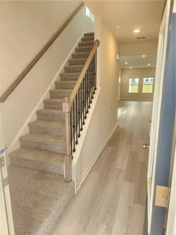 a view of staircase with lots of frames and a rug