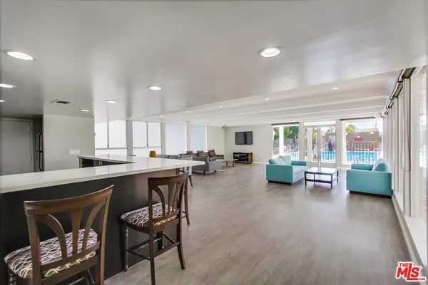 a kitchen with a table chairs and wooden floor