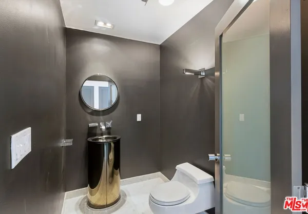 a bathroom with a toilet a sink and mirror