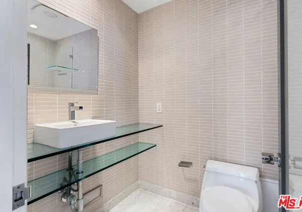 a bathroom with a sink a toilet and mirror