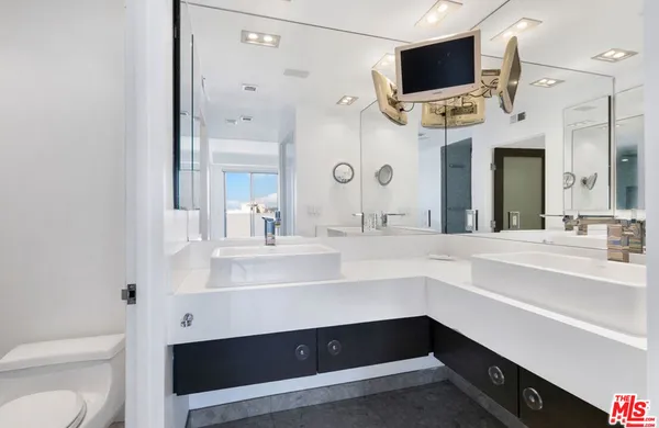 a bathroom with a sink a large mirror and a toilet
