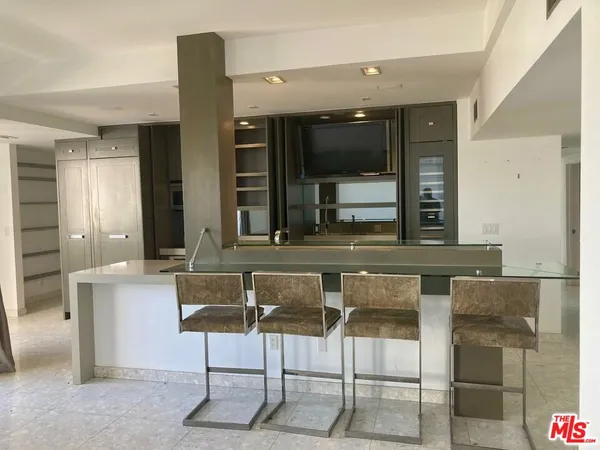 a living room with a sink and a large mirror with wooden floor