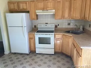 a kitchen with a stove top oven and refrigerator