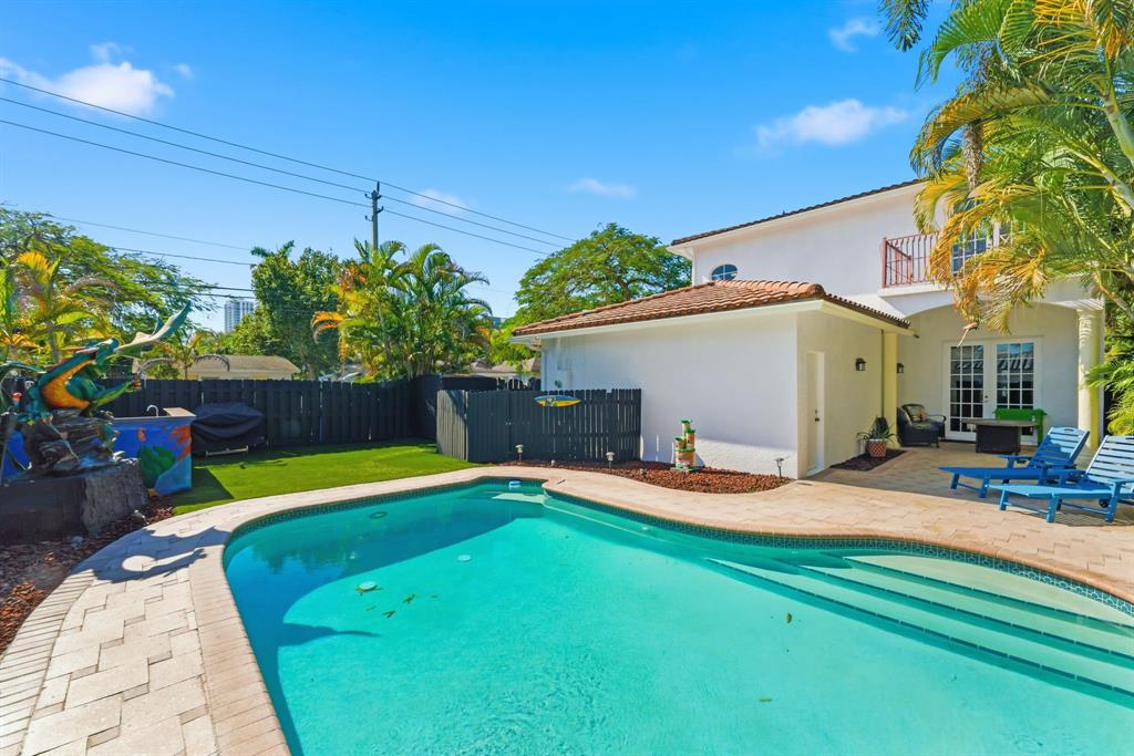 400 Northeast 8th Avenue Fort Lauderdale, FL 33301 - Photo 21 of 25 a backyard of a house with table and chairs under an umbrella