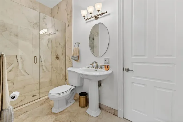 a bathroom with a sink a toilet and shower