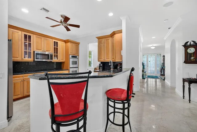 a kitchen with stainless steel appliances granite countertop a refrigerator and a stove top oven