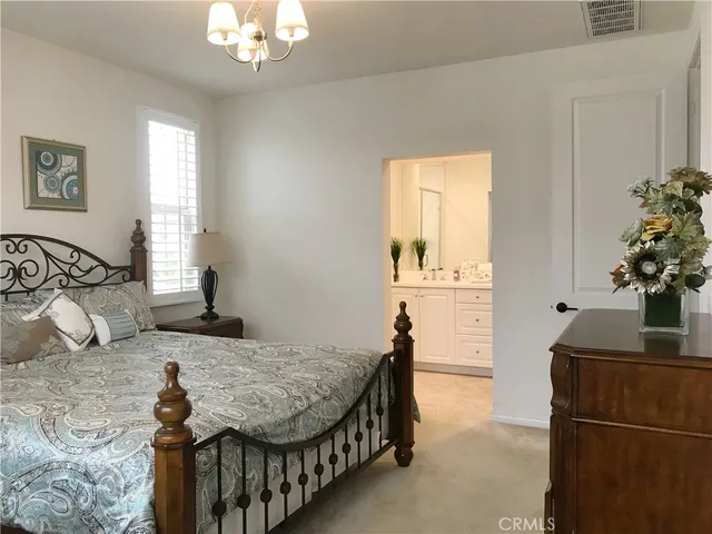 a bedroom with a bed a dresser and window