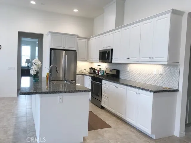 a kitchen with refrigerator and cabinets