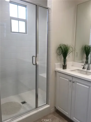 a bathroom with a shower sink and mirror