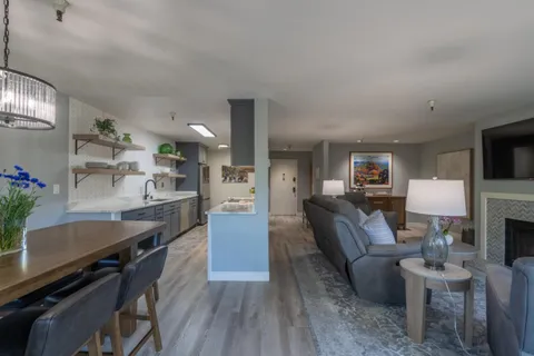 a living room with furniture a dining table and kitchen view