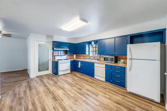 a kitchen with stainless steel appliances granite countertop a stove top oven a refrigerator a sink and dishwasher with wooden cabinets